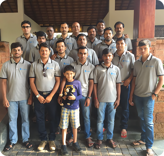 Group of employees posing together in matching team shirts at an outdoor venue.
